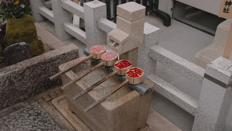 traditional japanese shinto water purification fountain at jishu-jinja shrine in kiyomizudera temple in kyoto, japan