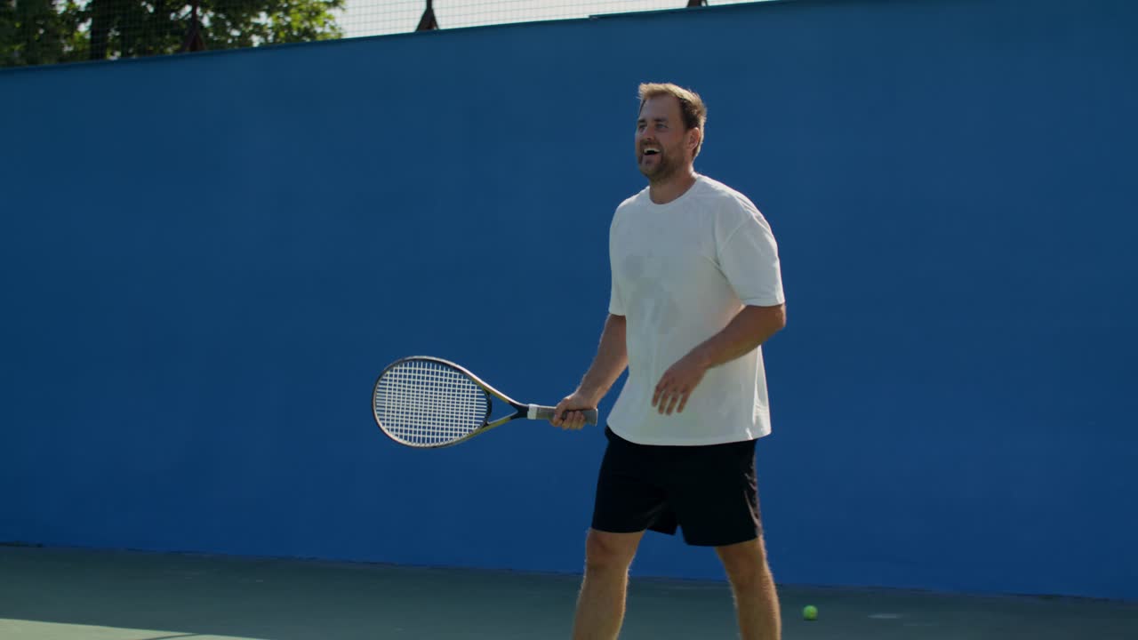 Mann som spiller tennis på bane