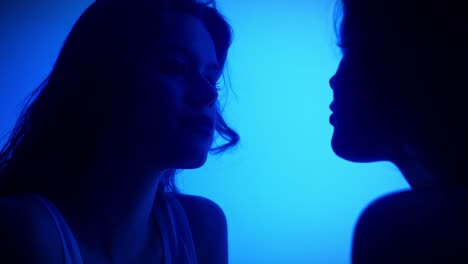 reflection of a face in a mirror on a pink background an artistic photograph depicting a reflection of a face in a mirror with tongues sticking out against a bright pink background slow motion