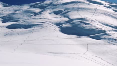 drone moving over snowboarders walking in the mountains. aerial shot of freeriders walking in snow.