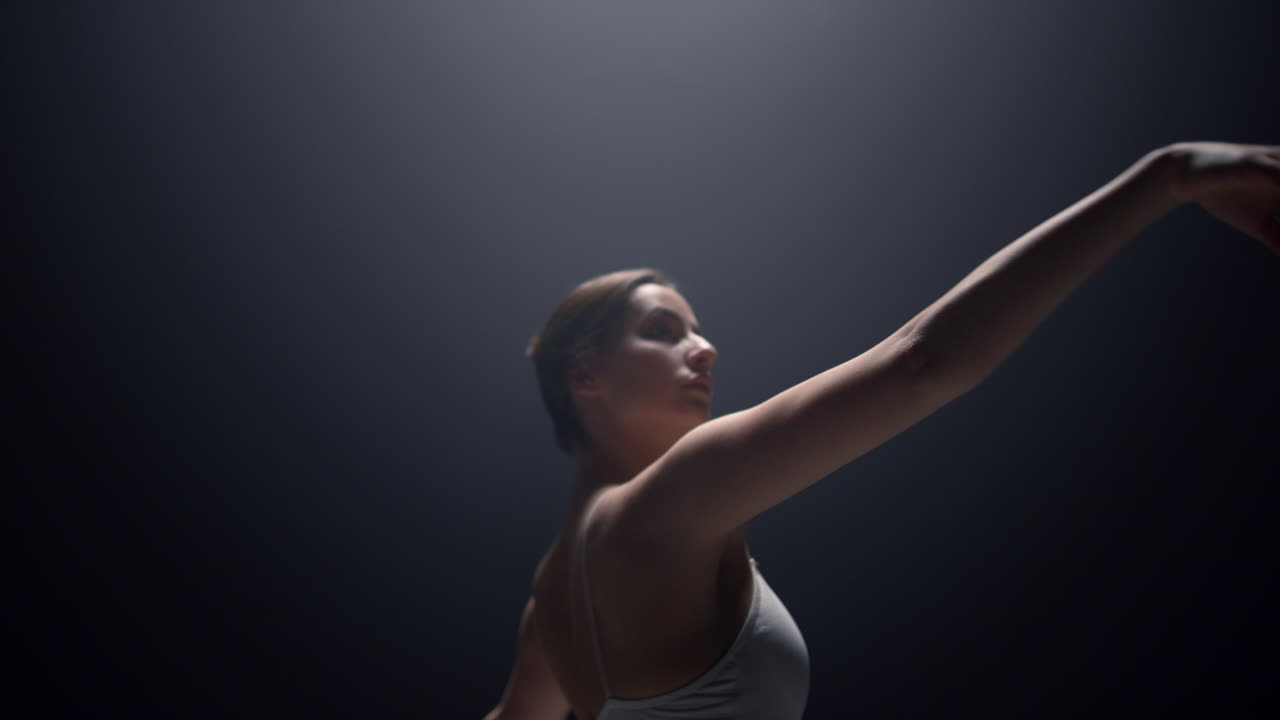 atractiva bailarina moviendo las manos suavemente en el escenario. bailarín de ballet practicando.