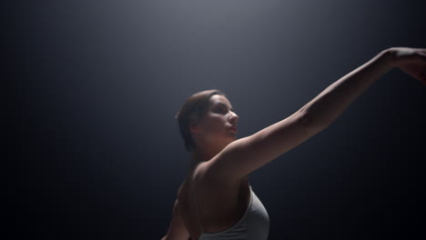 attractive ballerina moving hands smoothly on stage. ballet dancer practicing.