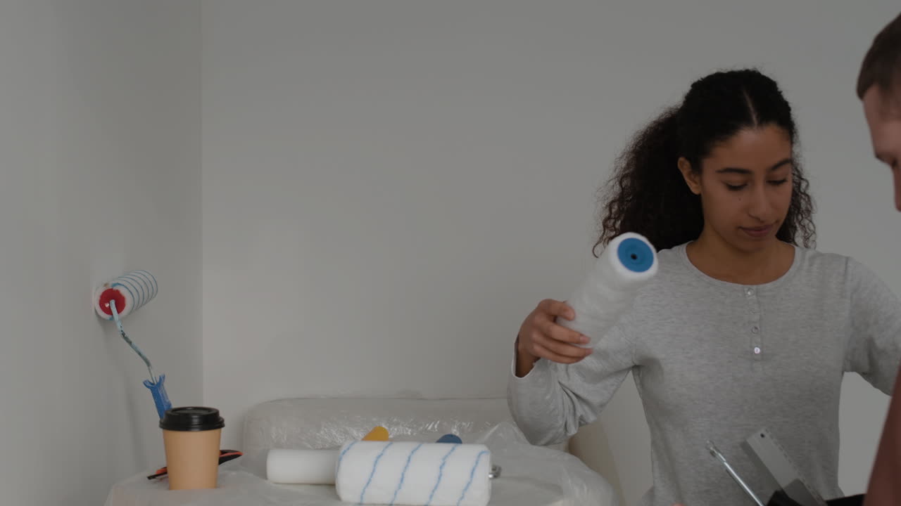 Young Couple Painting Their Room Together