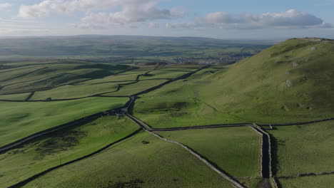 establishing aerial shot of fields in yorkshire dales and hilly landscape