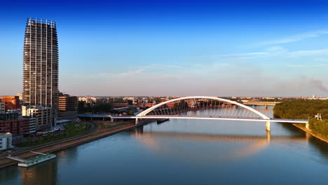 cars run by the beautiful appolo bridge over the danube river. sunset in bratislava, slovakia. aerial view