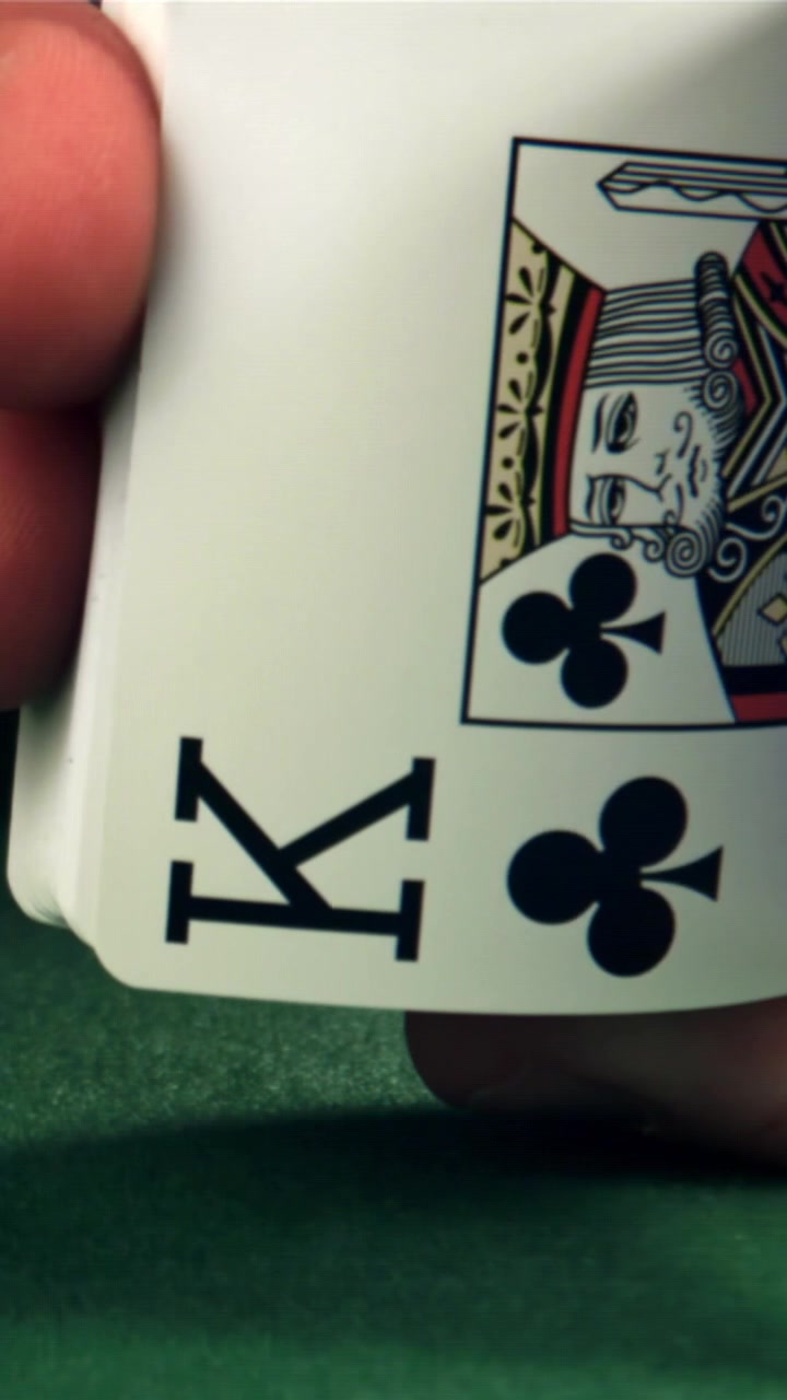 Close-up de uma mão abrindo um leque de cartas de baralho