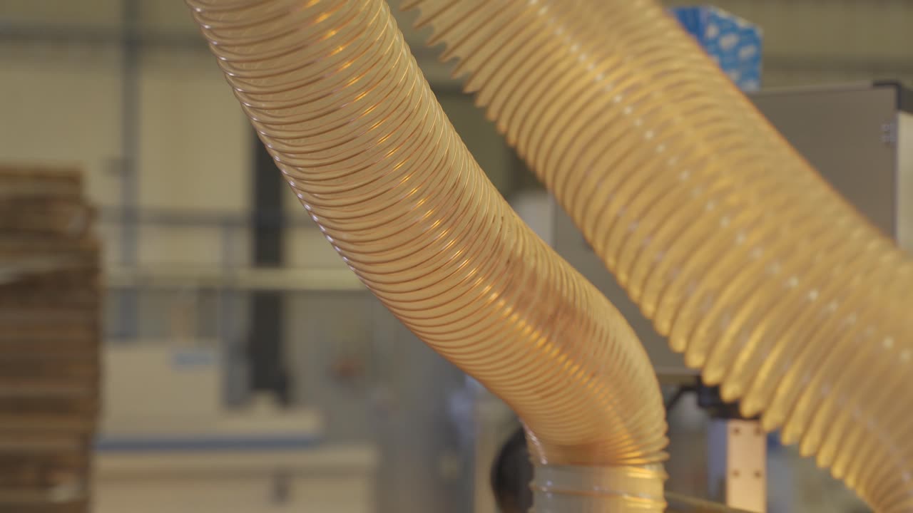 Nærbillede af fleksibel slange til en industriel udsuger i funktion.