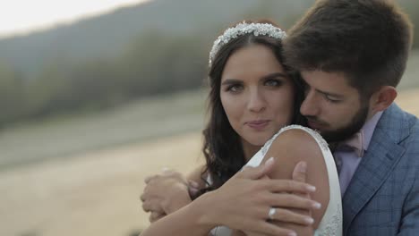 pareja de bodas de pie cerca del río de la montaña. novio y novia enamorados