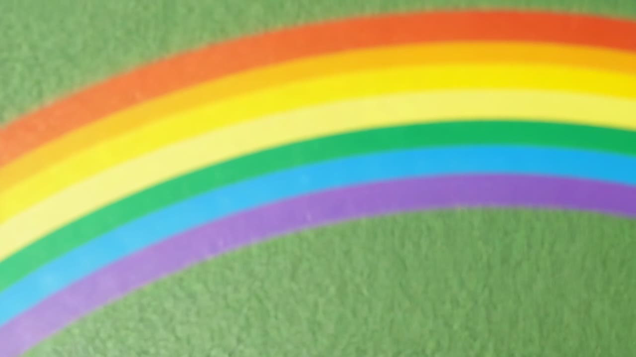 Cámara en movimiento estabilizando el enfoque sobre tela verde texturizada, revelando un nítido arcoíris de siete bandas.