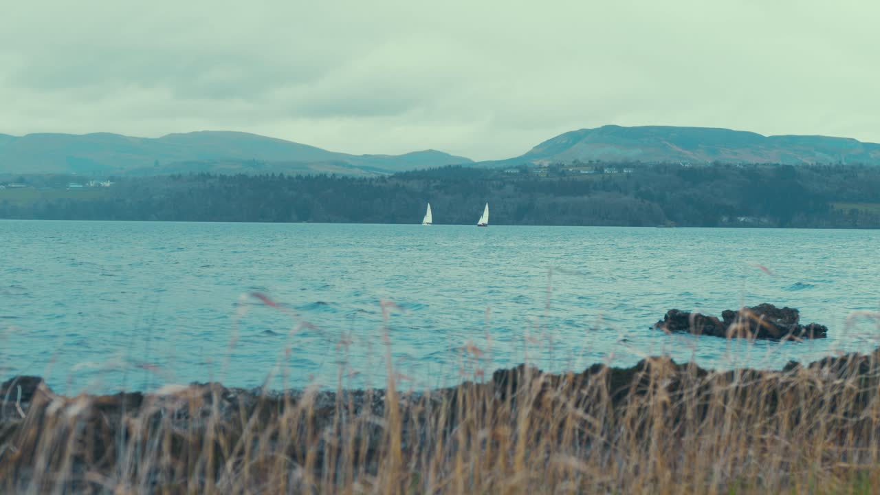 живописный вид на озеро стойка фокус на две парусные лодки расстояние 4k