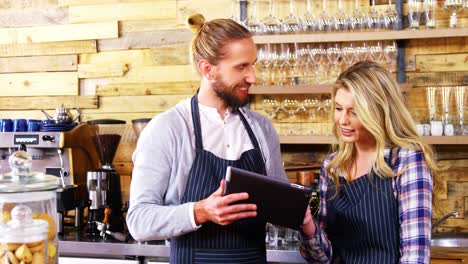 waiter and waitresses using digital tablet at counter