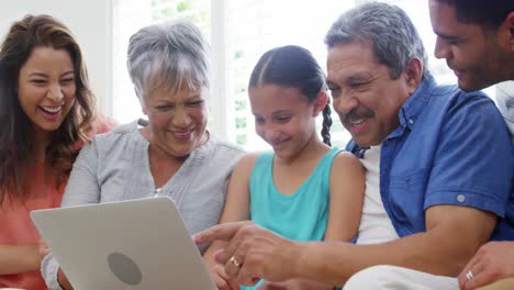 Happy-family-sitting-on-sofa-and-using-laptop