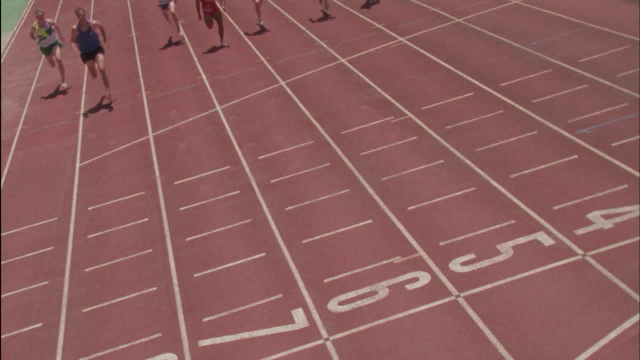 los corredores corren por la pista hacia la línea de meta