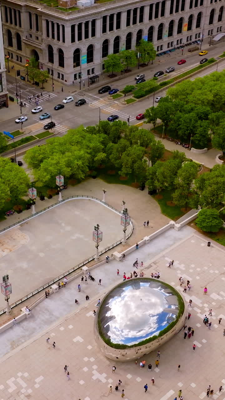 Famous Bean sculpture in Millennium Park in Chicago, Illinois. Well-known landmark at the backdrop of beautiful city architecture. Vertical video