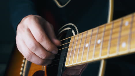 musician plays on stainless steel strings of acoustic guitar