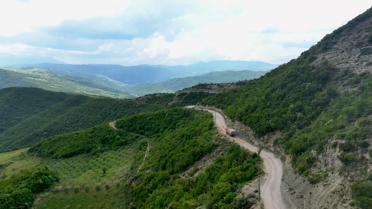 산길 을 가로질러 시골 도로 에 운전 하는 덤프 트럭