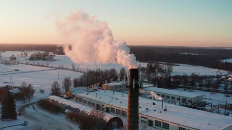 aerial view during sunset golden hour of high chimney release smoke in air