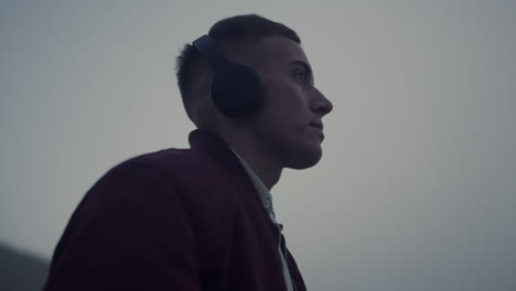 calm guy listening music headphones closeup. enthusiastic man making dance moves