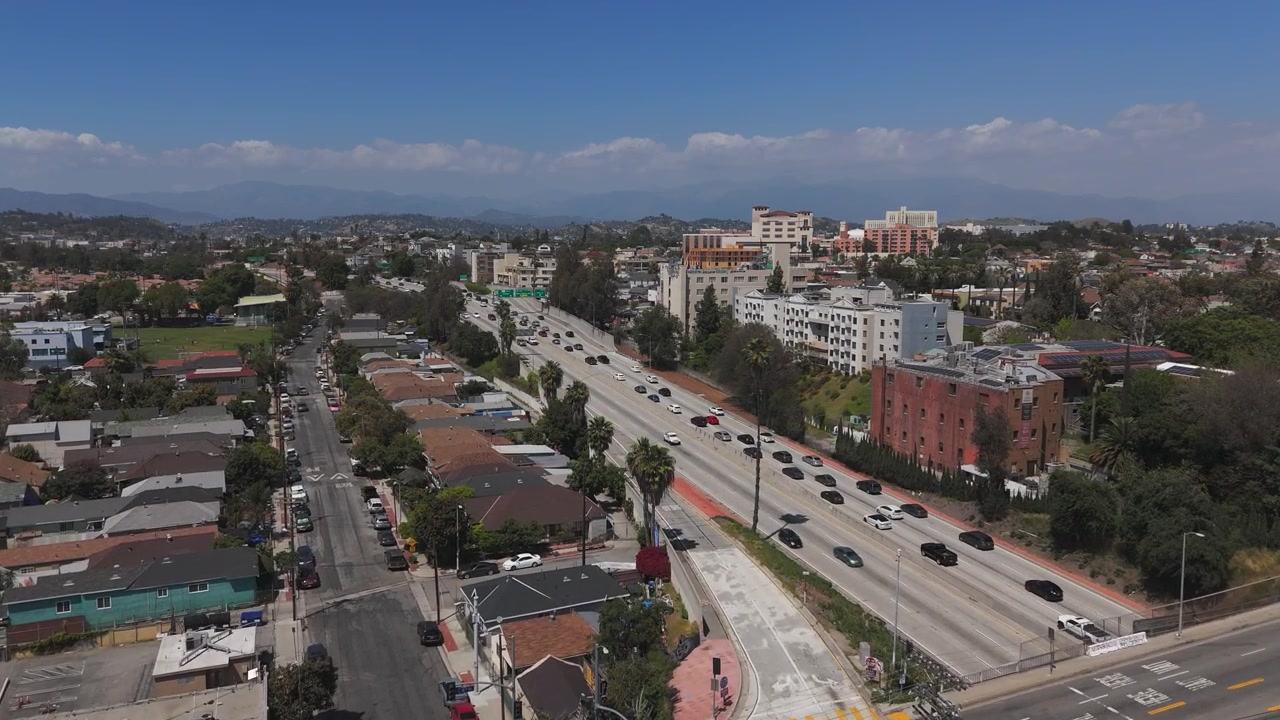 Autostrada a Los Angeles con traffico in aumento. Cielo azzurro limpido in una giornata di sole in California. Ripresa aerea 4K 60fps.