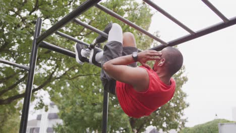 side view man with prosthetic leg doing abs suspended in the air