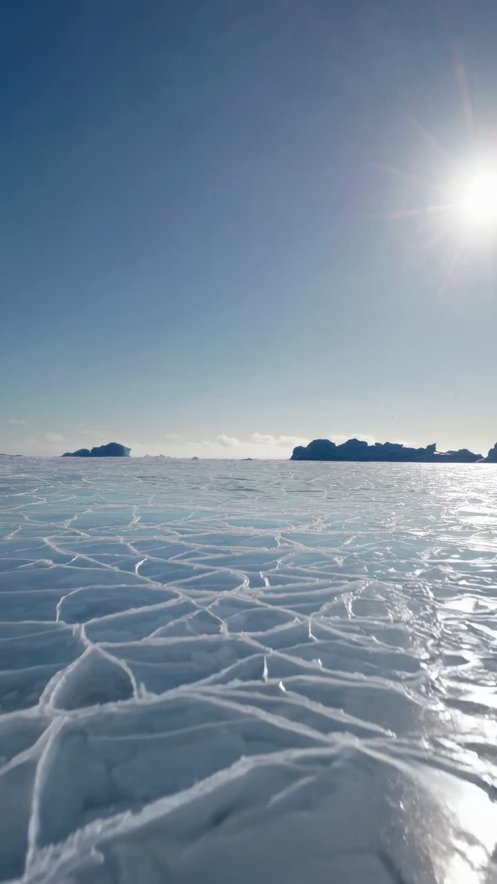 A mesmerizing video of cracked ice patterns on a frozen lake, captured from a low angle