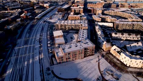 aerial of exterior facade residential housing at the ettegerpark during sunrise after a snowstorm with ettegerpark covered in snow