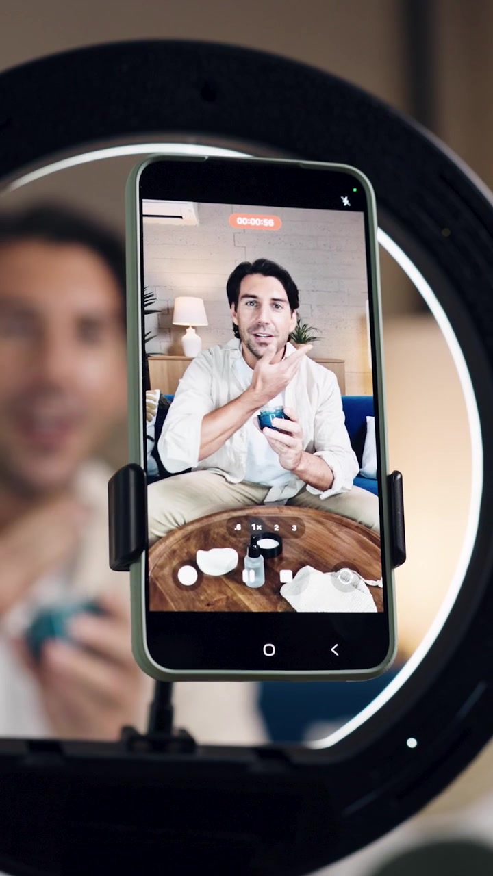 Uomo che registra un video tutorial sulla cura della pelle con lo smartphone