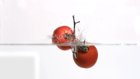 tomatoes falling into water in super slow motion