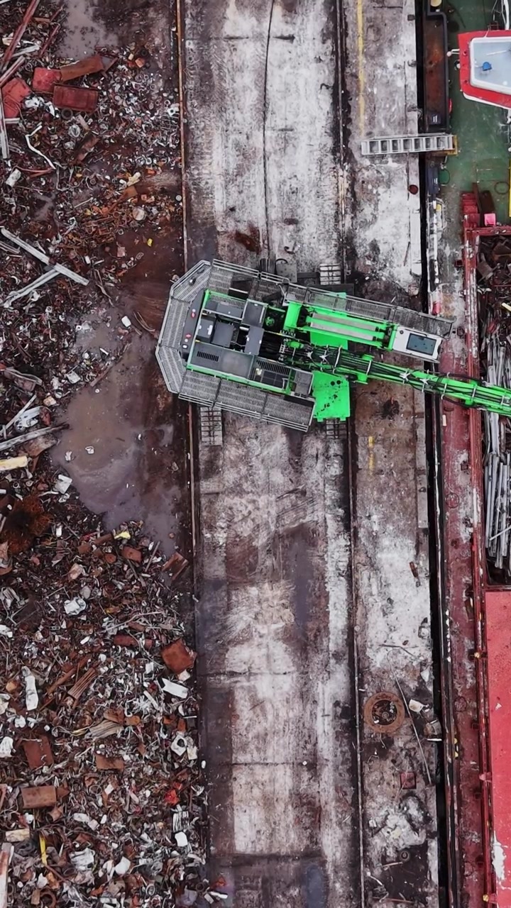Operazione in cantiere navale con una gru e una nave da carico in azione.