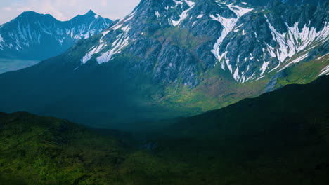 aerial over valley with snow capped mountains in distance