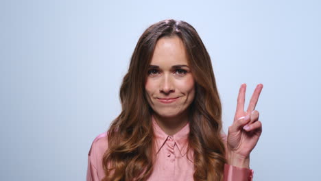 smiling businesswoman showing v sign. woman showing v gesture in studio