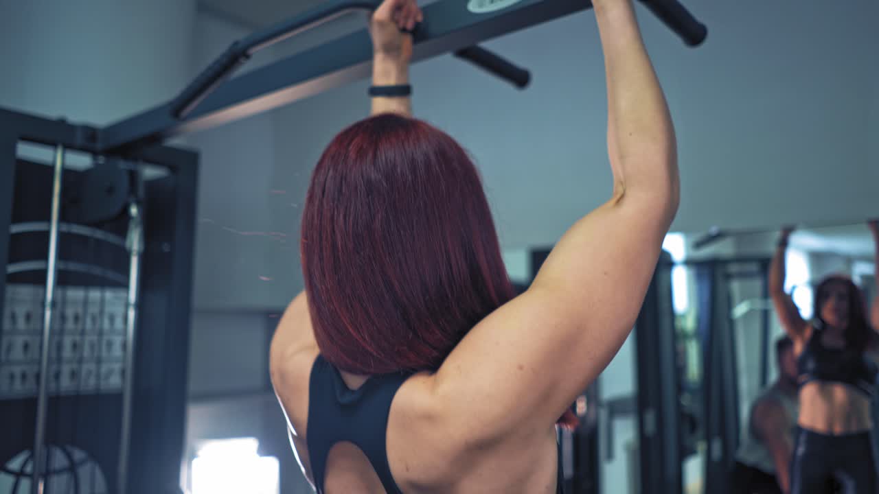 Muscular couple doing exercise. Close up view of training woman with trainer at gym