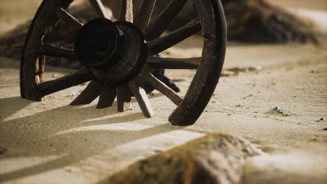 large wooden wheel in the sand