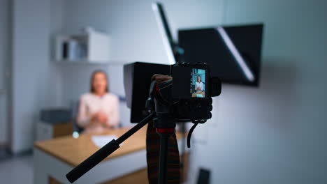 modern camera taking video of a female blogger. approaching closer to a display of camera. blurred backdrop.