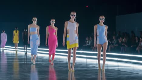 a stunning fashion showcase: models grace the runway in vibrant, contemporary styles featuring colorful outfits and bold accessories under dramatic lighting