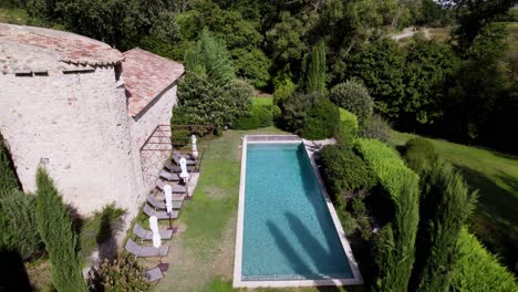 aerial establishing shot of a tropical swimming pool in the garden of a villa