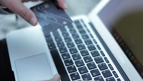 Young-man-making-online-purchases-from-laptop