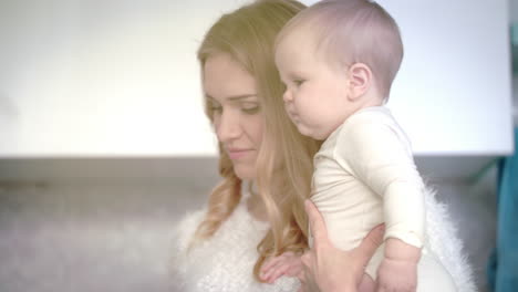 Madre-Sonriendo-Para-Bebé-En-Habitación-Blanca.-Mamá-Feliz-Con-El-Niño