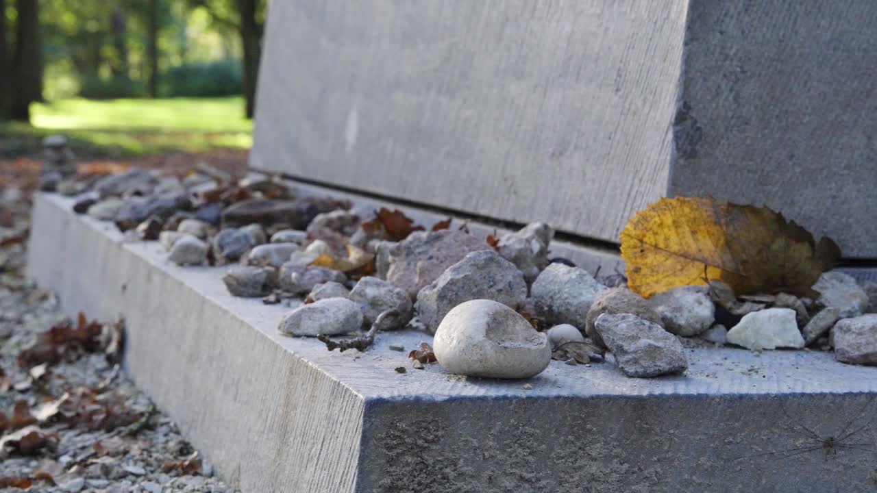 Close-up of a Grave with Stones and Autumn Leaves