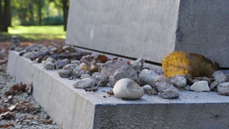 close-up of a grave with stones and autumn leaves