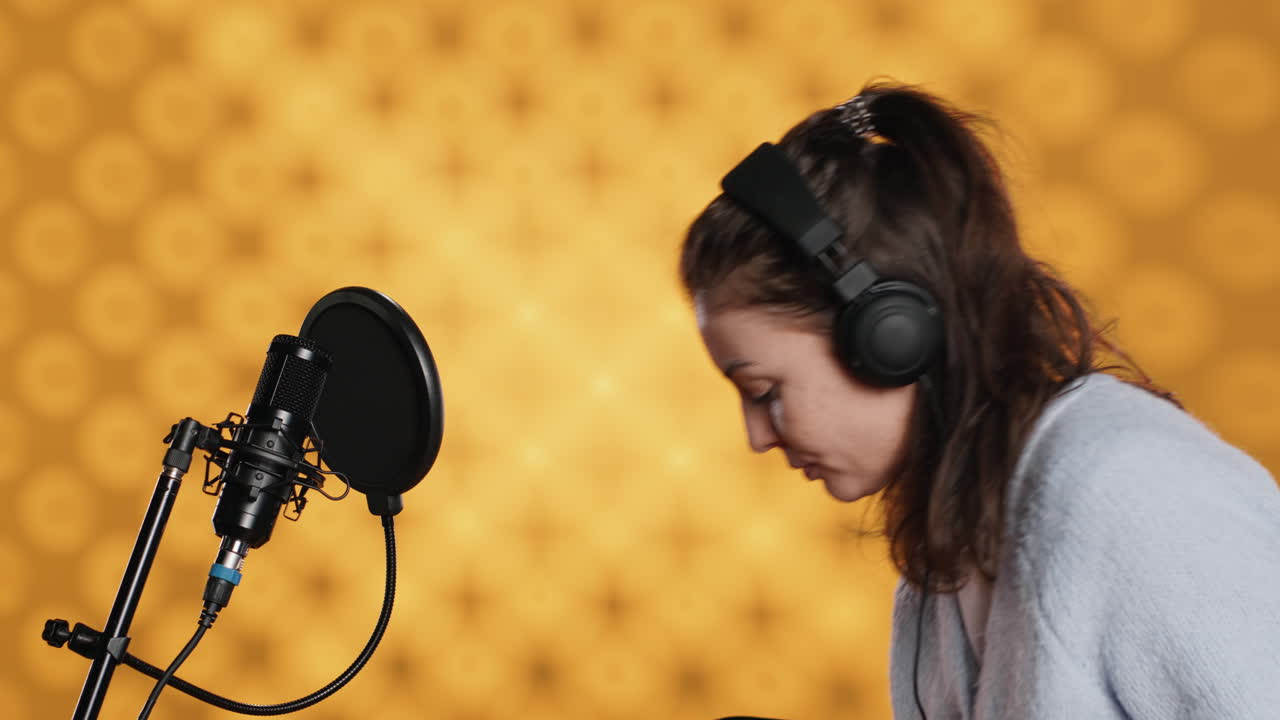 Donna che arriva in studio, indossa le cuffie e registra un audiolibro.