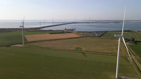 Holländisches-Ackerland-Nahe-Der-Nordsee-Mit-Zahlreichen-Windkraftanlagen-Entlang-Des-Oosterschelde-Sturmflutwehrs-Im-Hintergrund
