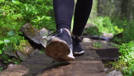 close-up-of-girl-walking-through-the-woods-on-a-hiking-path-in-Golden,-British-Columbia,-Canada