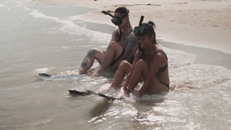 couple putting diving fins on