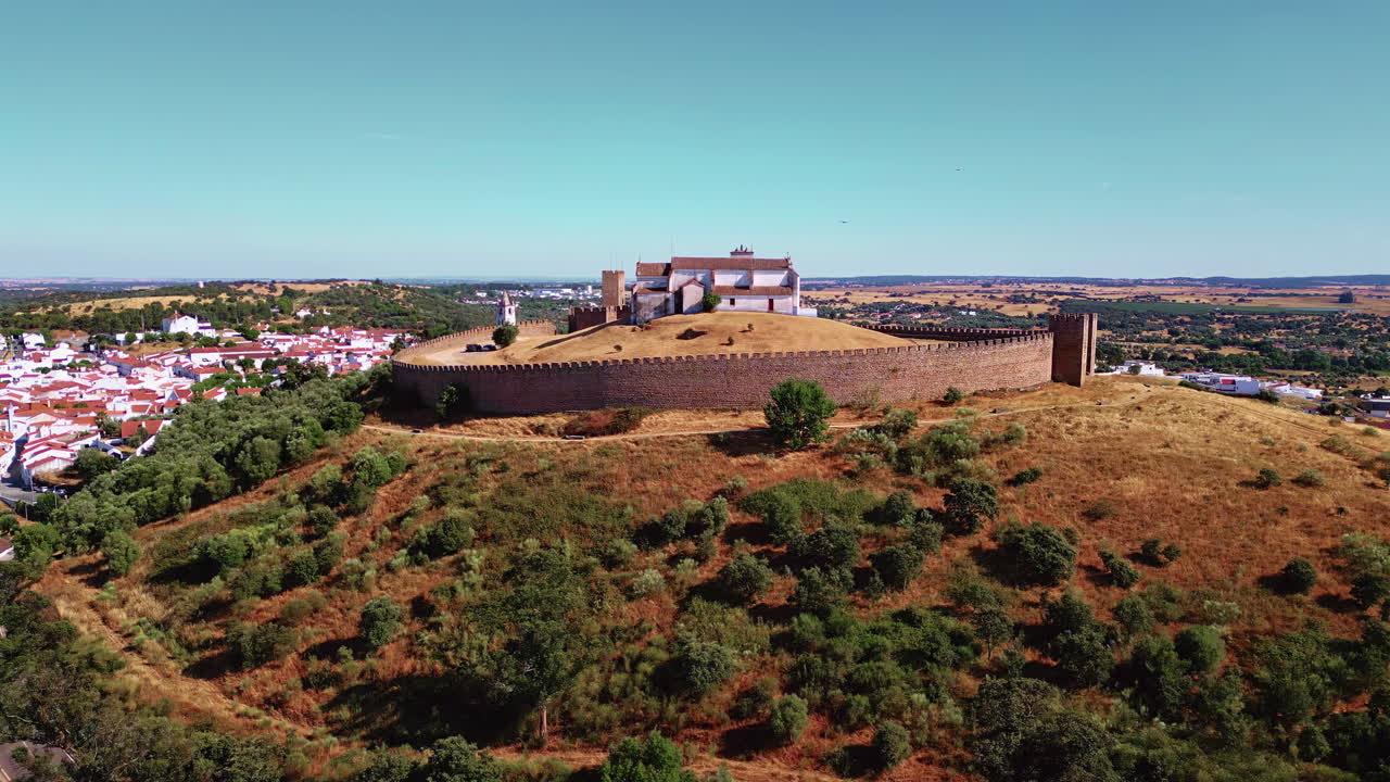 Antica fortezza aerea che si erge sopra un villaggio portoghese. Mura di pietra che circondano la cappella