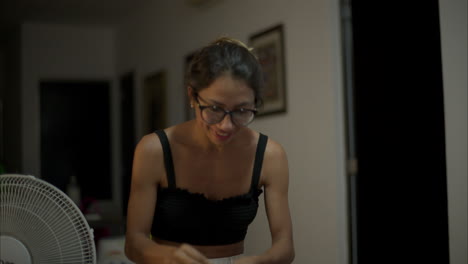 cámara lenta de una mujer delgada latina con gafas jugando un juego con amigos actuando como si estuviera comiendo algo y luego como volando