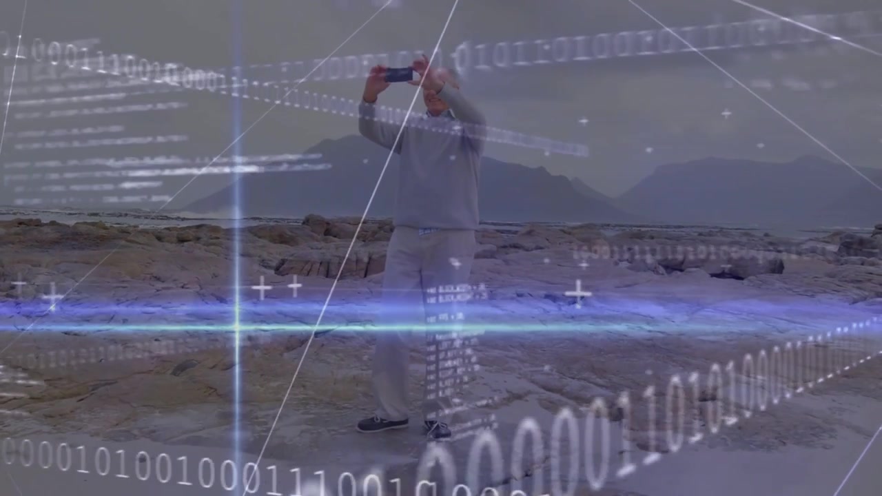 Vertical video: Spotting ridge, raising device, senior man framing coastal view with binary HUD
