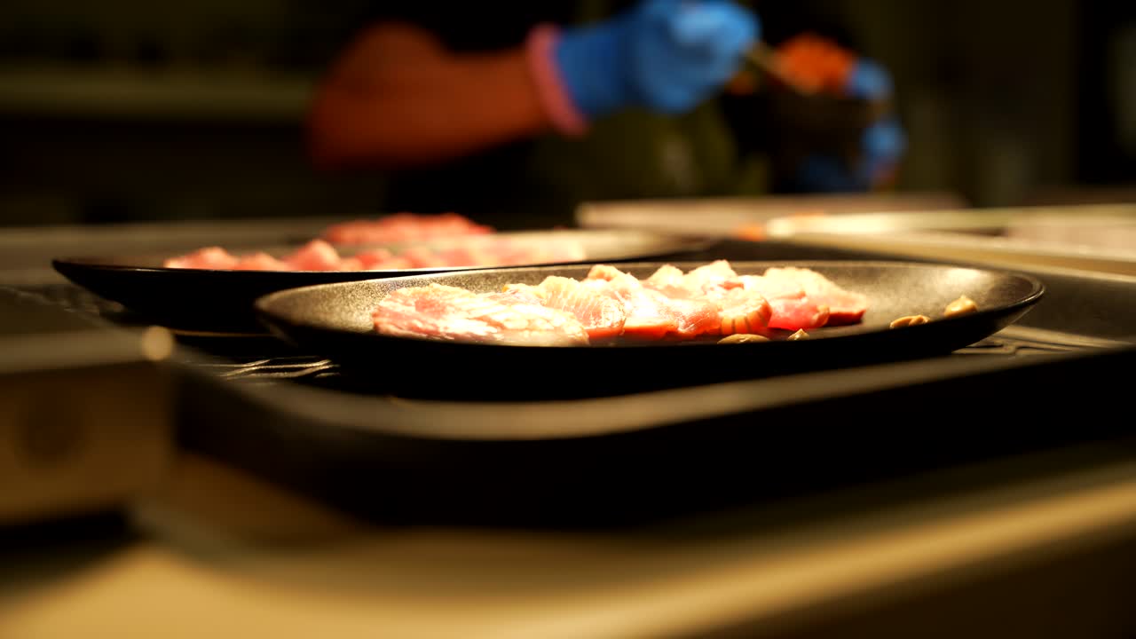 Prepared dishes showcased and ready to be served at table. Chef working in background