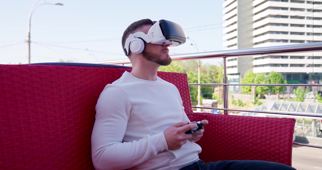 Giovane uomo che gioca a un videogioco in realtà virtuale con controller all'aperto