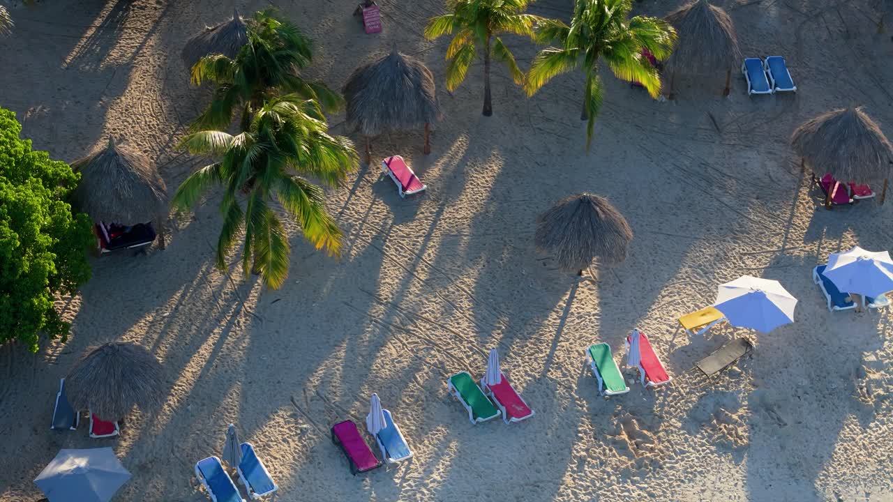 vibrantes hermosas sillas de playa de colores y paraguas de palma tropicales en la playa del caribe